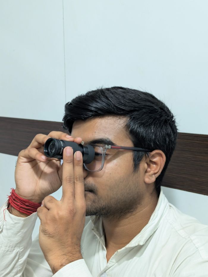 Man using an ophthalmoscope for eye examination in a clinical setting.